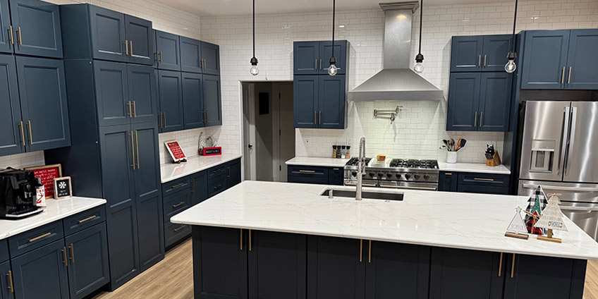 Modern kitchen with light gray cabinetry, a large island with seating, and stainless steel appliances.